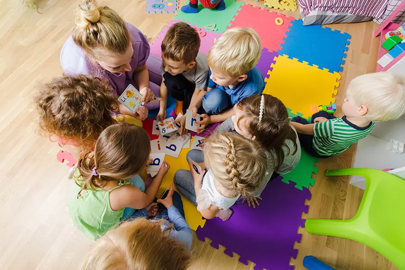 Group of toddlers learning from a caretaker